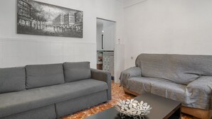 A living room with two grey sofas, a black coffee table, and a large black-and-white cityscape painting on the wall. - Chalet 'Casa El Molino' with Mountain View, Wi-Fi and Air Conditioning (Montecorto)