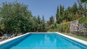 A swimming pool with a dolphin mosaic, surrounded by greenery and a stone wall. - Chalet 'Casa El Molino' with Mountain View, Wi-Fi and Air Conditioning (Montecorto)