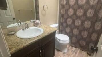 Bañera con ducha, toallas, jabón, papel higiénico