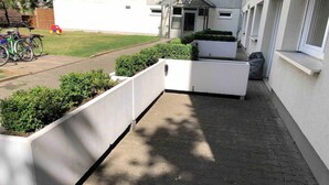 A paved outdoor area with white planters and a bicycle. - Potsdamer Platz-Top Spot Studio 1 (Berlin)