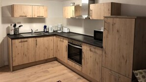 A compact kitchen with wooden cabinets, a built-in oven, and a microwave. - TOP SPOT- KREUZBURG CENTRAL THE PLACE TO BE ! (Berlin)