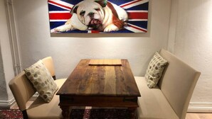 A dining area with a wooden table and two beige chairs, a British Bulldog painting on the wall, and a patterned rug on the floor. - TOP SPOT- KREUZBURG CENTRAL THE PLACE TO BE ! (Berlin)