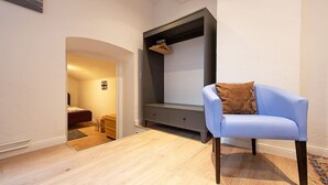 A room with a blue armchair, a small desk with drawers, a wardrobe, and a bed in the background. - TOP SPOT- KREUZBURG CENTRAL THE PLACE TO BE ! (Berlin)