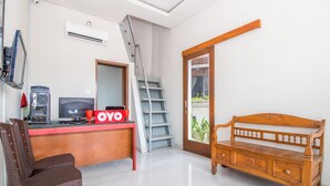 A room with a wooden desk, a computer, a chair, a wooden bench, and a ladder.