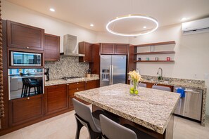 A modern kitchen with granite countertops, stainless steel appliances, and wooden cabinetry. - Gorgeous 1 Bedroom Unit at V399, amazing Rooftop 1BD Condo for rent in Old Town, (Puerto Vallarta)