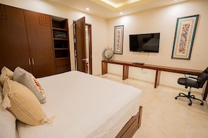 A bedroom with a bed, a desk, a chair, a wardrobe, and a television. - Gorgeous 1 Bedroom Unit at V399, amazing Rooftop 1BD Condo for rent in Old Town, (Puerto Vallarta)