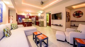 A modern living room with a sofa, ottoman, and a small table with a clock. - Gorgeous 1 Bedroom Unit at V399, amazing Rooftop 1BD Condo for rent in Old Town, (Puerto Vallarta)