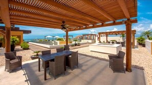 Relax in a serene outdoor space with a pergola overhead, a fire pit, and comfortable seating.