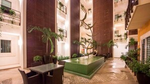 A spacious indoor courtyard with a central water feature, surrounded by potted plants and furnished seating areas. - Gorgeous 1 Bedroom Unit at V399, amazing Rooftop 1BD Condo for rent in Old Town, (Puerto Vallarta)
