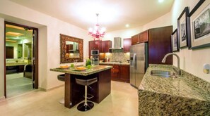 A modern kitchen with granite countertops, stainless steel appliances, and a bar area with stools. - Gorgeous 1 Bedroom Unit at V399, amazing Rooftop 1BD Condo for rent in Old Town, (Puerto Vallarta)