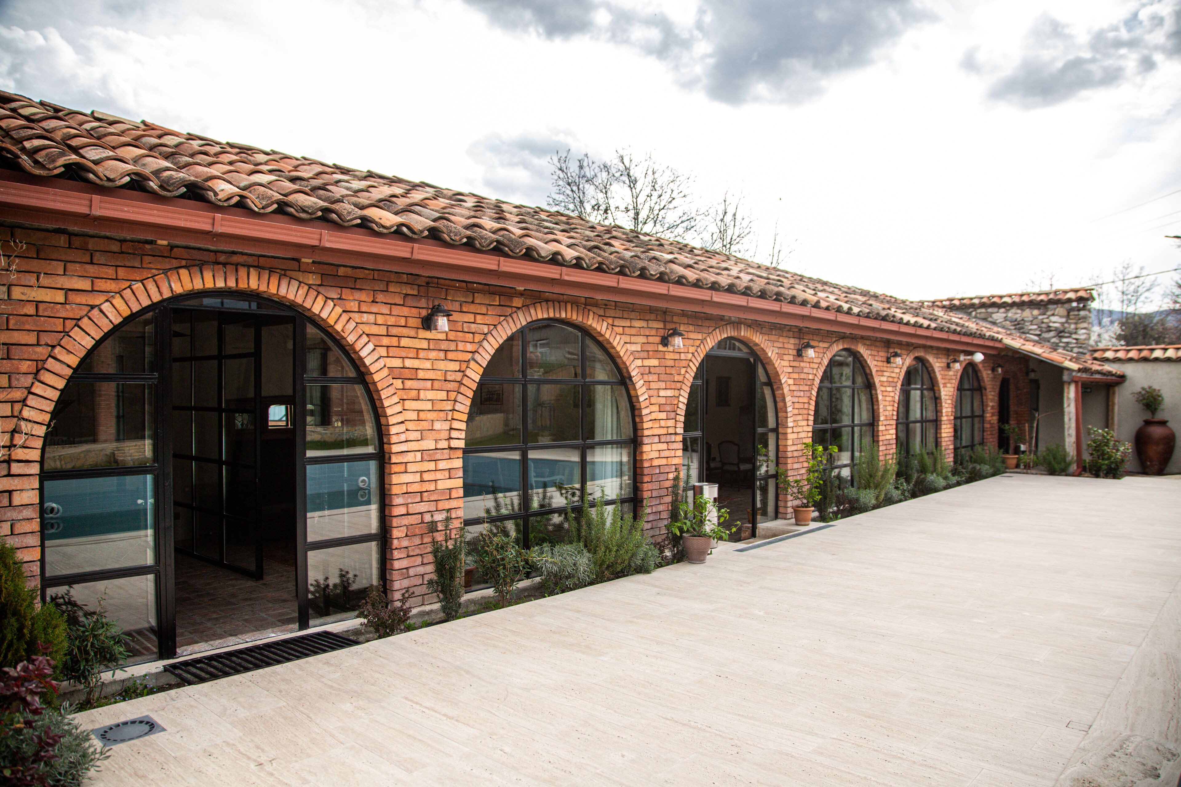 A building with a tiled roof, brick arches, and large windows.