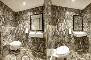 A bathroom with marble walls, two sinks, and two toilets. - Town Pallace Inn (New Delhi)