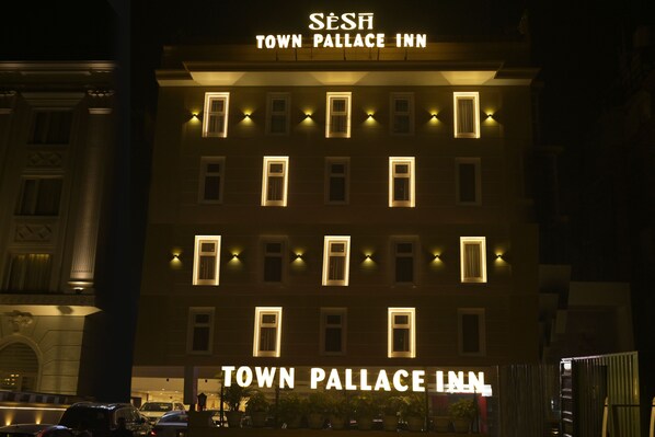 The exterior of the Town Pallace Inn with illuminated windows and a sign above the entrance. - Town Pallace Inn (New Delhi)