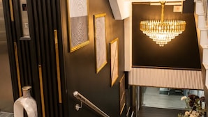 A modern interior with a staircase, a chandelier, and framed artwork on the walls. - Raissa Boutique Hotel (Kuala Lumpur)