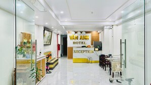A hotel reception area with a reception desk, a clock, and a sign that reads 'VAN ANH HOTEL.' - Vân Anh Hotel (Hanoi)