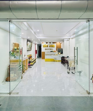 A hotel reception area with a reception desk, a clock, and a sign that reads 'VAN ANH HOTEL.' - Vân Anh Hotel (Hanoi)