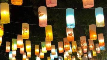 Escena nocturna con numerosas linternas de papel de colores colgando de cables, creando un ambiente festivo.