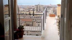 Ein Balkon mit Blick auf Stadt und Meer.