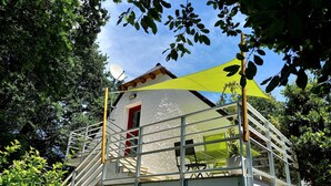 Ein Gebäude mit roter Tür, einem Balkon mit Metallgeländern und einem gelben Markisen