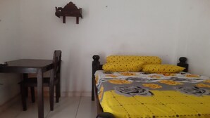 Une chambre à coucher avec un lit, une chaise en bois et une petite table.