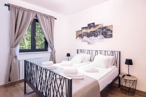 A neatly made bed with white linens, a black metal headboard, and a bedside table with a lamp. - VILLA PORTUM - Serenity, Nature, Heated Pool, FAMILY ONLY (Labin)