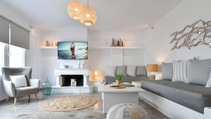 Ein modernes Wohnzimmer mit Kamin, einer Couch und einem Fernseher.