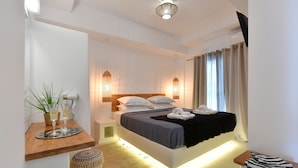 Ein modernes Schlafzimmer mit Bett, Nachttischchen, einem kleinen Hocker und Beistelltisch.