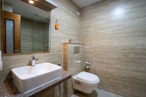 A modern bathroom with a rectangular sink, a toilet, and a glass shower enclosure. - Avocado and Orchid Resort (Hetauda)