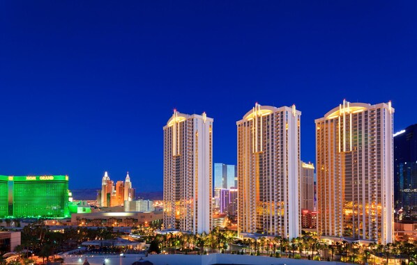 A high-rise hotel with multiple floors, a prominent casino in the background, and a well-lit urban skyline.