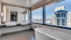 Un baño moderno con una bañera grande, dos lavamanos y un espejo amplio.
