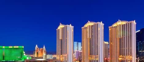 Un hotel de gran altura con varios pisos, un casino destacado al fondo y un horizonte urbano bien iluminado.