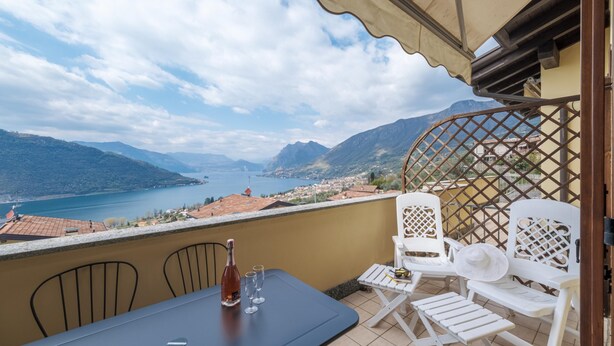 Ein Balkon mit Tisch, Stühlen und einer Weinflasche.