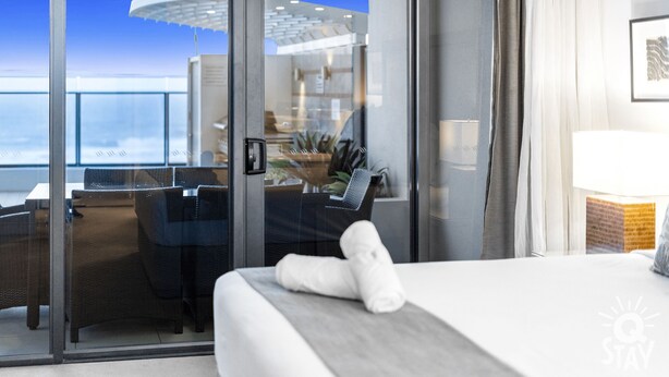 A hotel room with a balcony, a desk, and a bed. - 2 Bedroom Apartment With Private Plunge Pool (Surfers Paradise)