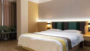 A hotel room with a bed, two bedside tables, a chair, and a curtain.