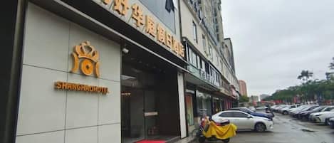 A hotel with a prominent sign and a red carpet entrance.