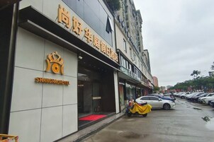 Un hotel con un letrero llamativo y una alfombra roja en la entrada.