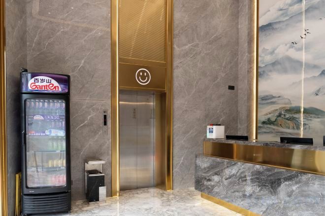 A reception area with a vending machine, an elevator, and a wall with a mural.