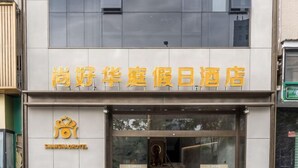 Een hotel met een moderne gevel en een opvallend bord met gele letters.