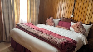 Una cama con una colcha estampada, almohadas y un cabecero de madera.
