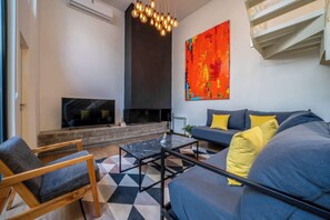Ein modernes Wohnzimmer mit einer Couch, einem Sessel und einem Couchtisch.