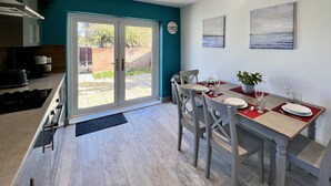 Una cucina moderna con zona pranzo, ampie finestre e vista sull'esterno.