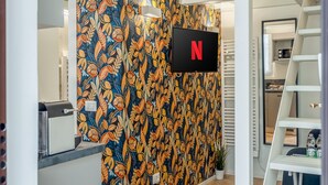 A modern interior with a patterned wall, a Netflix sign, and a staircase. - [Mini Loft Milano-Buenos Aires] WiFi-Netflix-Metro (Milano)