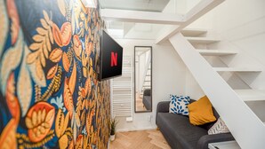 A modern living room with a sofa, a TV mounted on a wall, and a staircase. - [Mini Loft Milano-Buenos Aires] WiFi-Netflix-Metro (Milano)