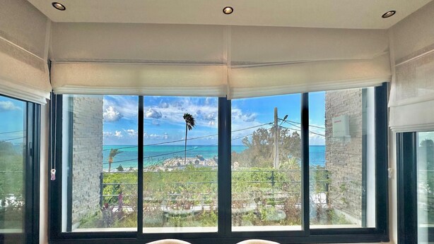 Una habitación con un amplio ventanal que da a la vista del litoral.