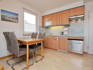 A compact kitchen with wooden cabinets, a built-in microwave, and a Siemens oven.