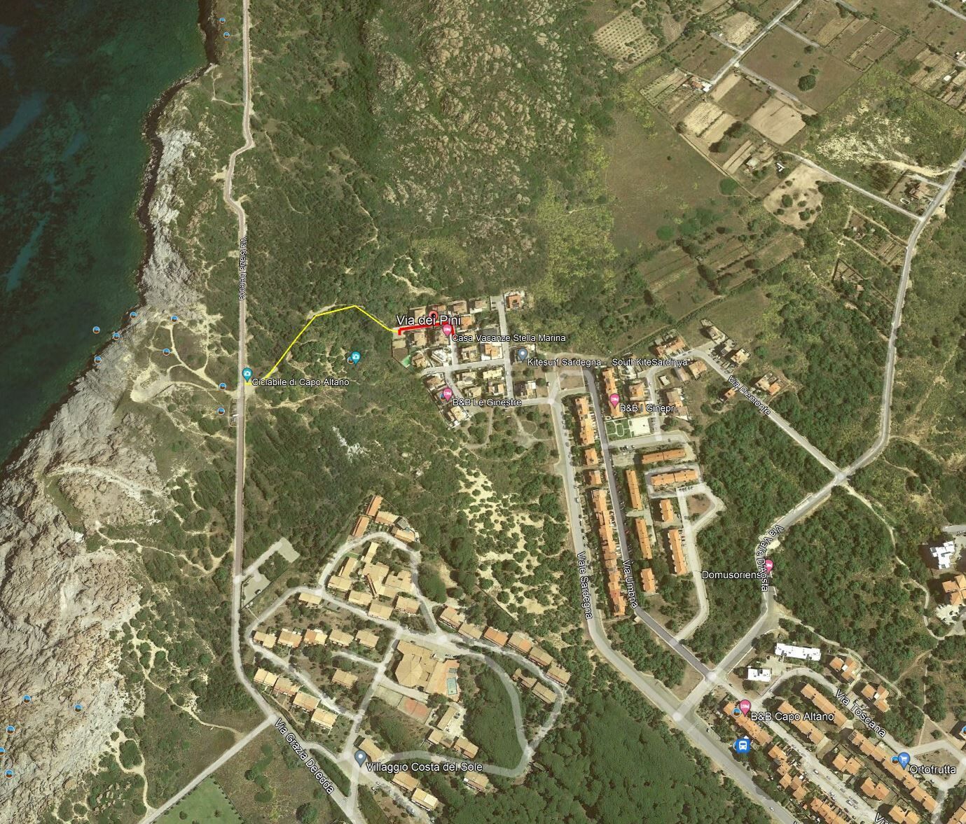 Eine Küstenstadt mit einer zentralen Straße, mehreren Gebäuden und einem Strandabschnitt.