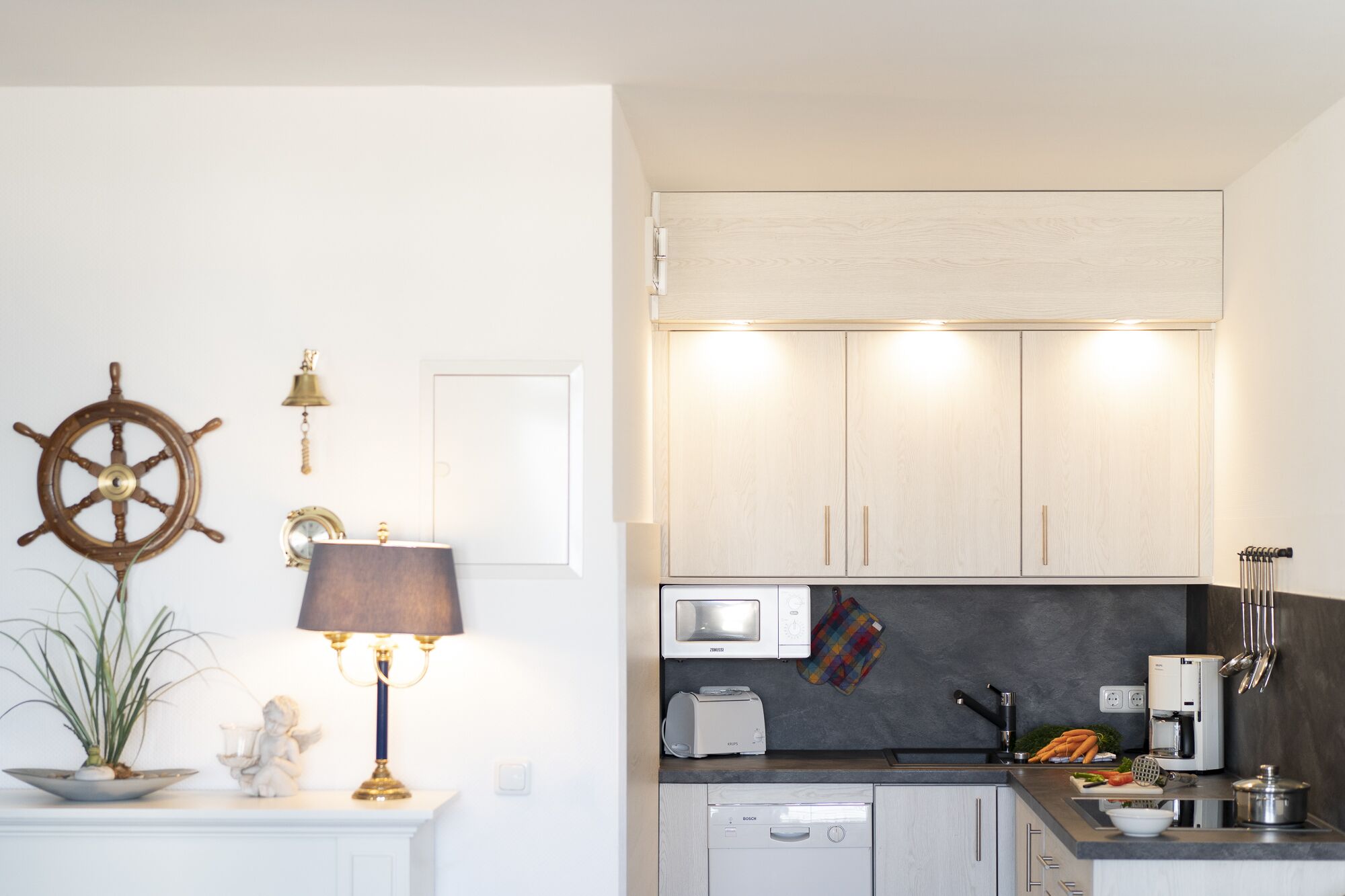 A compact kitchen with white cabinets, a microwave, a toaster, and a dishwasher.