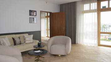 Un salon moderne avec un canapé, un fauteuil et une table basse.
