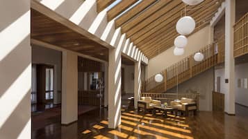 A spacious interior with high ceilings, wooden beams, and a sloped ceiling design.