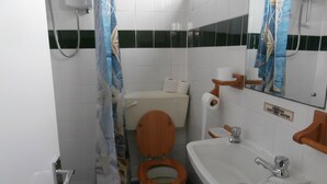 A bathroom with a wooden toilet, a sink, and a shower. - Inviting 2-bed Chalet in Mablethorpe (Mablethorpe)